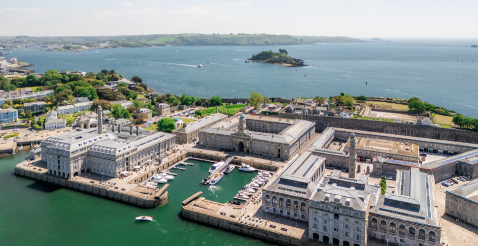Aerial view of Royal William Yard’s historic waterfront buildings and marina.